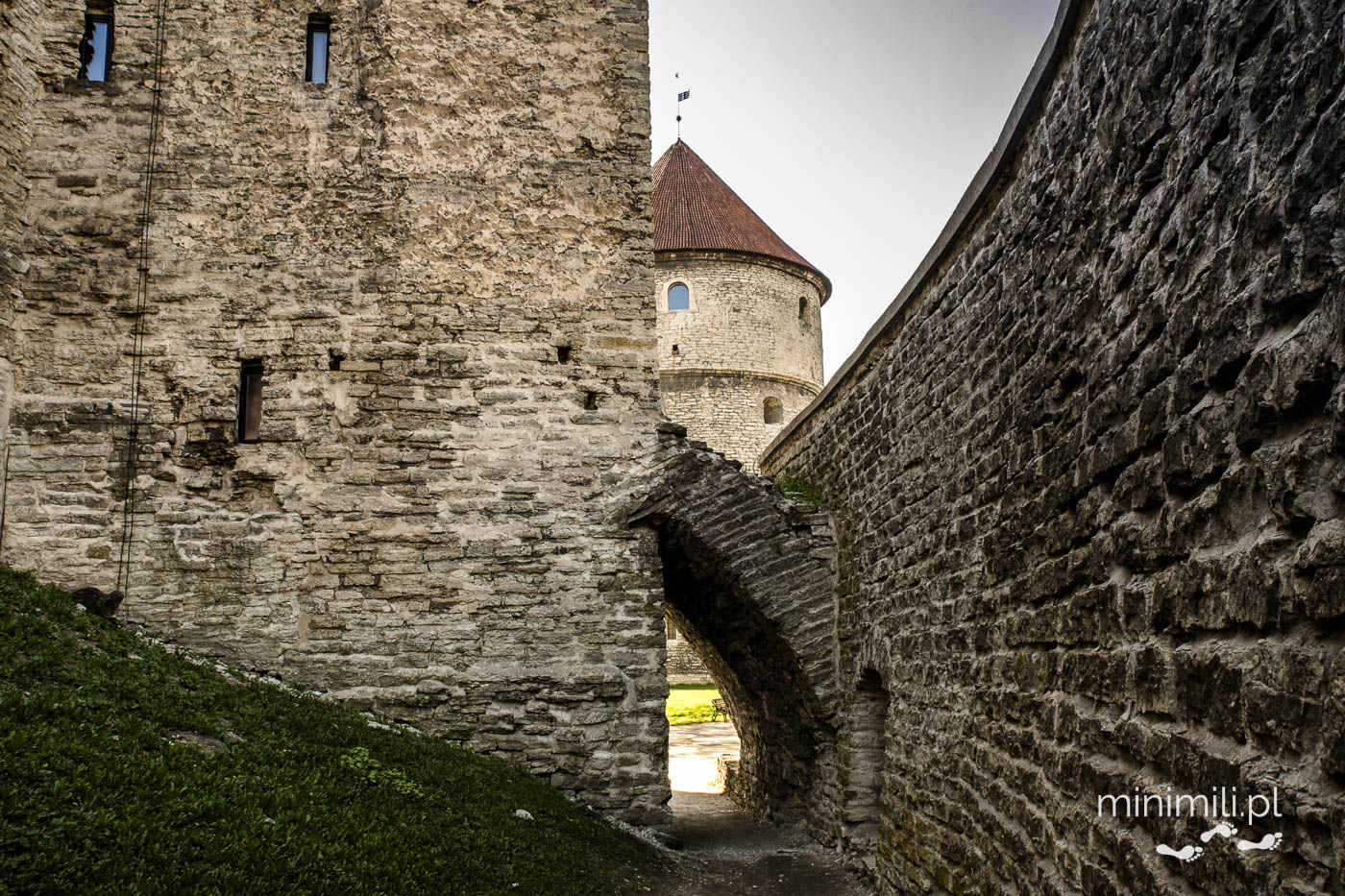Przejście przez średniowieczny mur obronny Tallinna z widokiem na baszty.