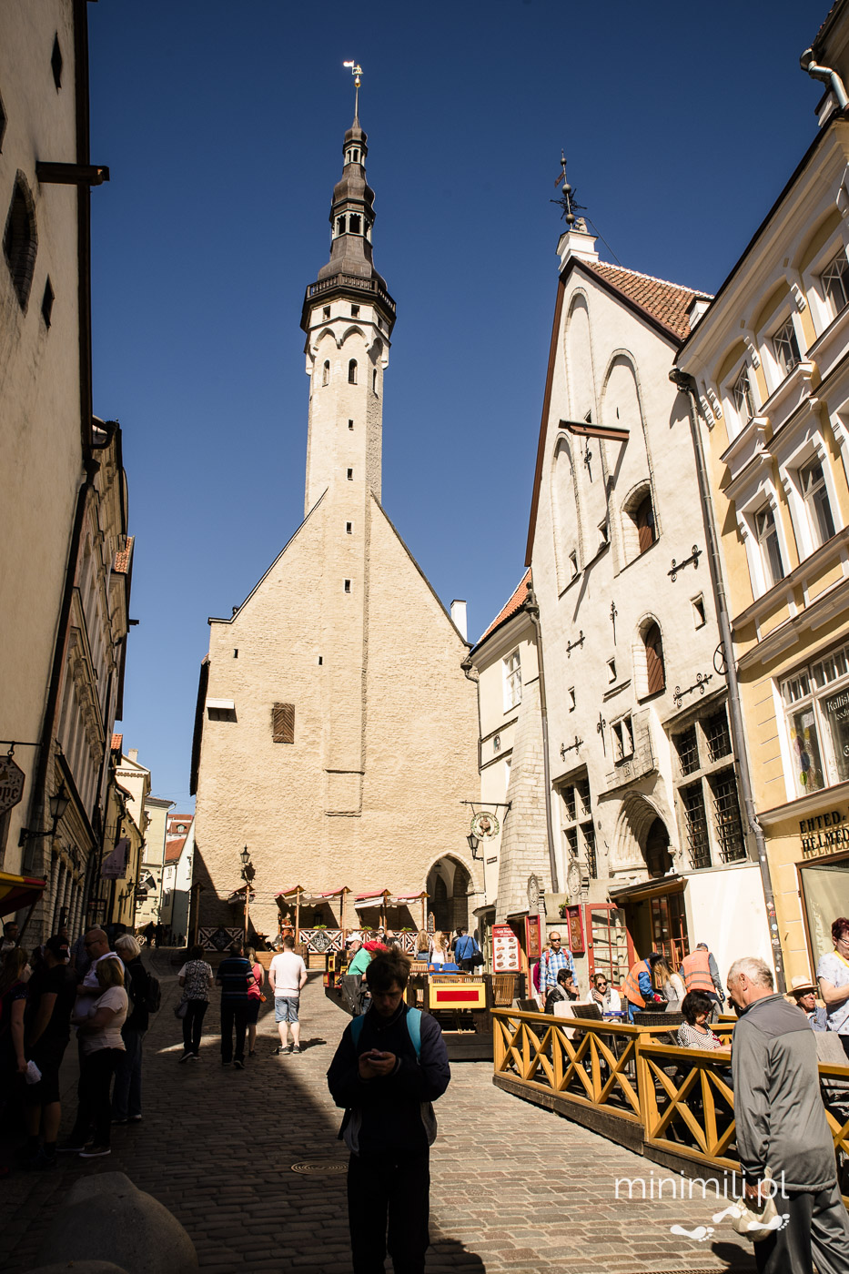 Widok na wieżę ratusza w Tallinnie z jednej z głównych ulic Starego Miasta.