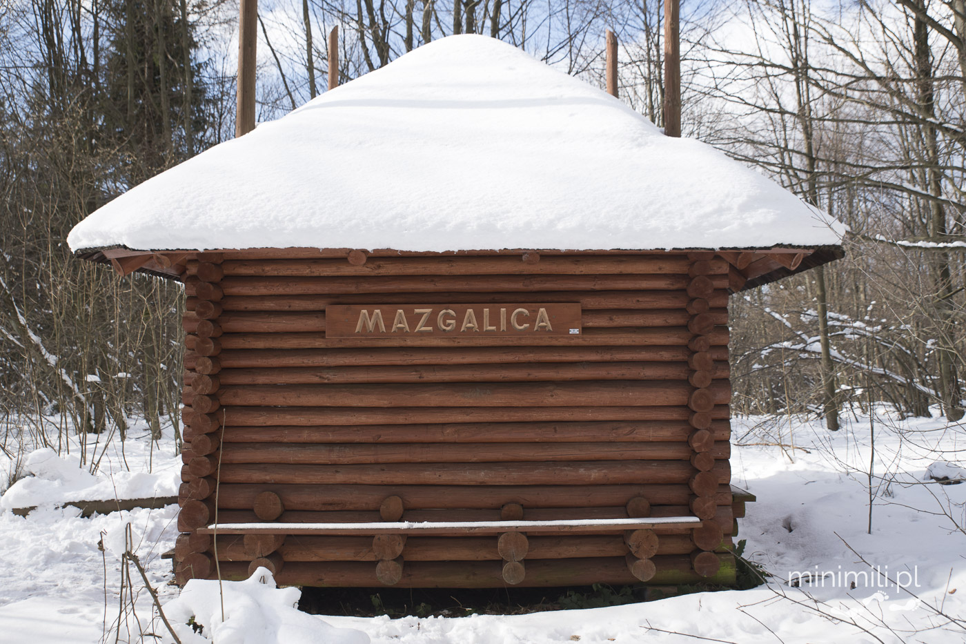 Drewniana wiata z napisem Mazgalica pokryta śniegiem