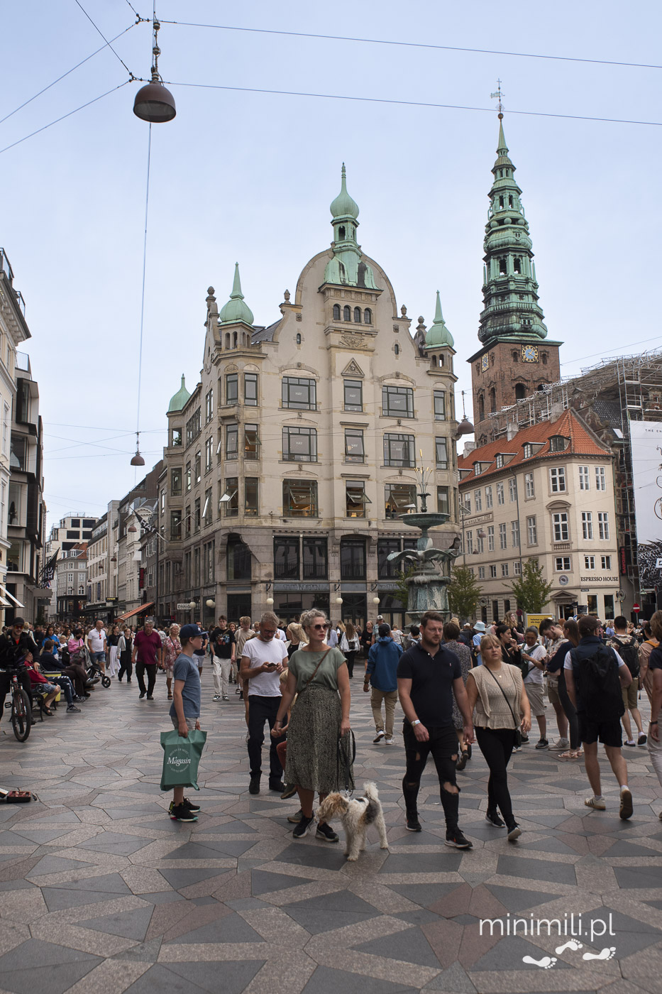 Zabytkowy budynek z wieżą i zielonym dachem przy Stroget  w centrum Kopenhagi