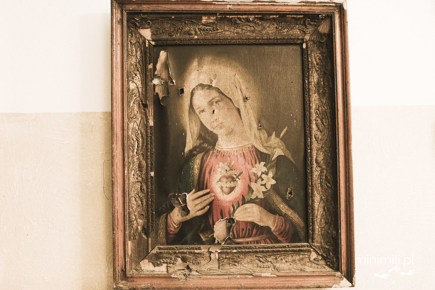 Stary obraz Matki Boskiej w zniszczonej ramie na ścianie muzeum