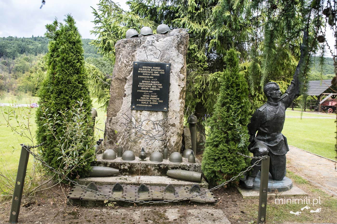 Kamienny pomnik z tablicą i figurą żołnierza w muzeum łemkowskim