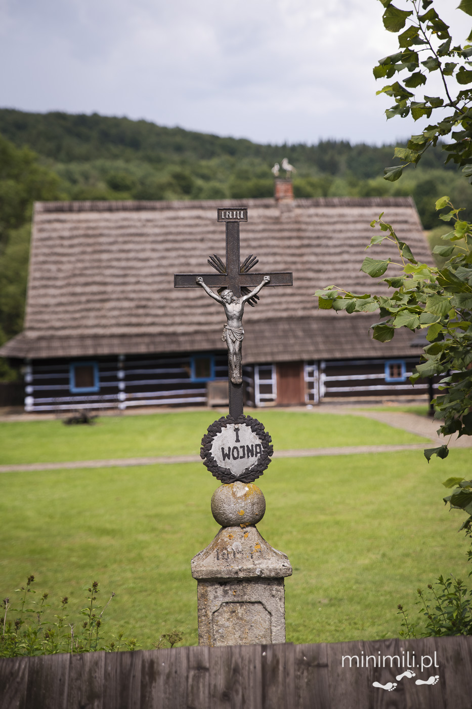 Metalowy krzyż z figurą Jezusa przed chatą w muzeum łemkowskim