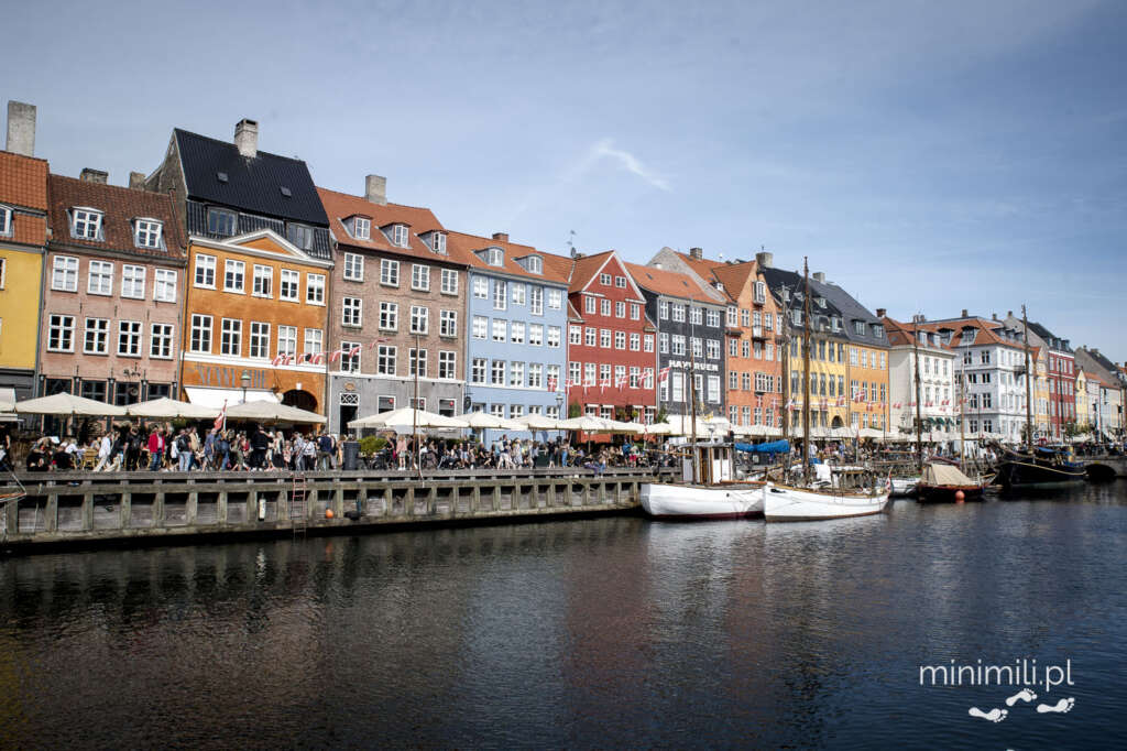 Panorama kanału Nyhavn z kolorowymi fasadami i spacerującymi ludźmi
