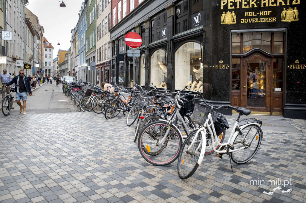 Rowerowa ulica w centrum Kopenhagi tuż przy Stroget z brukiem i witrynami sklepów
