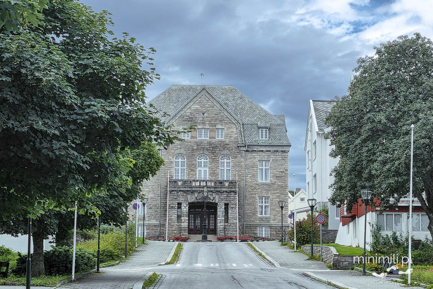 Gmach publiczny z ogrodem i drzewami przed wejściem