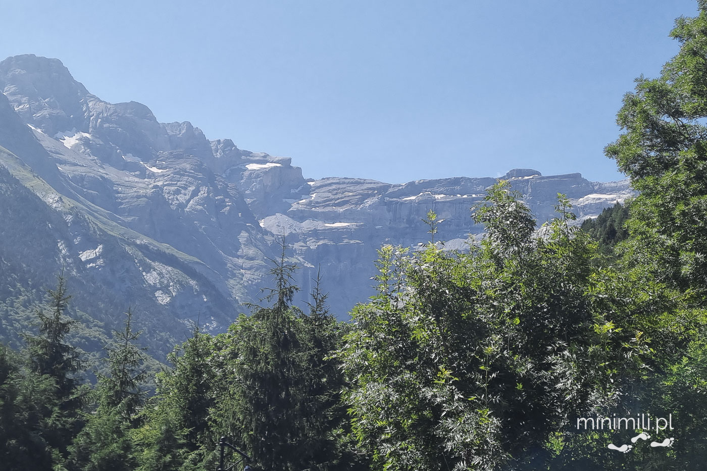 Cirque de Gavarnie widziane ponad koronami drzew w Pirenejach