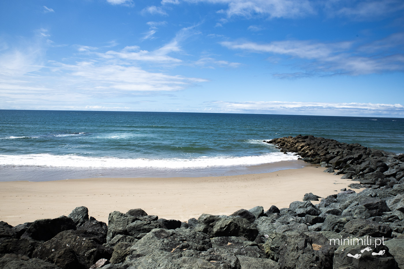 Piaszczysta plaża i kamienny falochron w Biarritz nad Oceanem Atlantyckim
