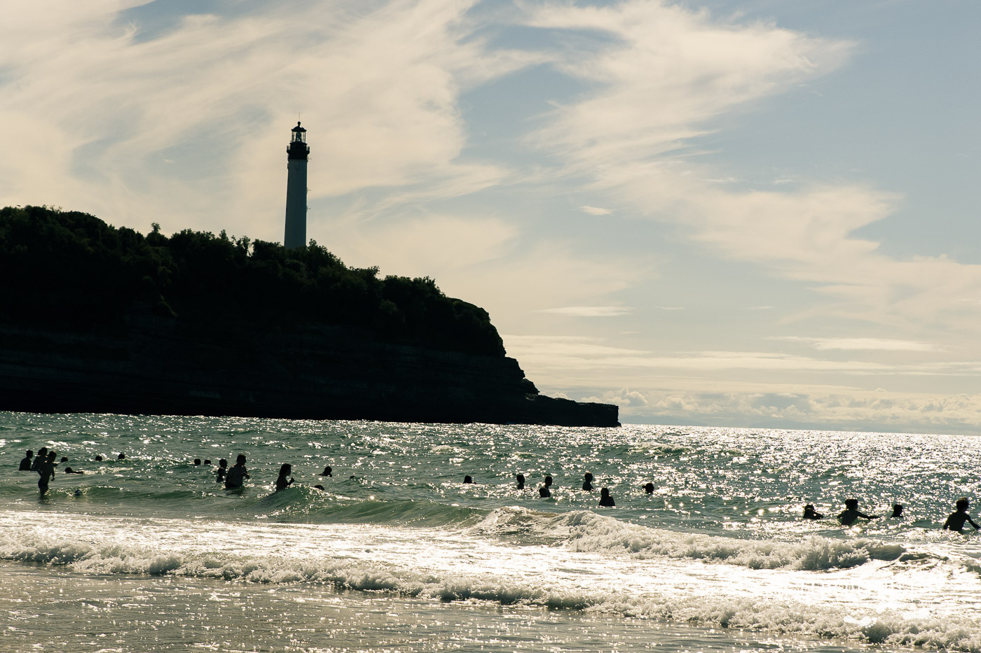 Latarnia morska w Biarritz i kąpiący się ludzie w oceanie