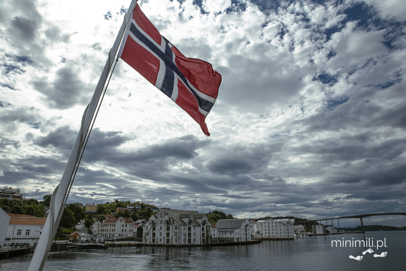 Norweska flaga na tle nieba i miasta Kristiansund
