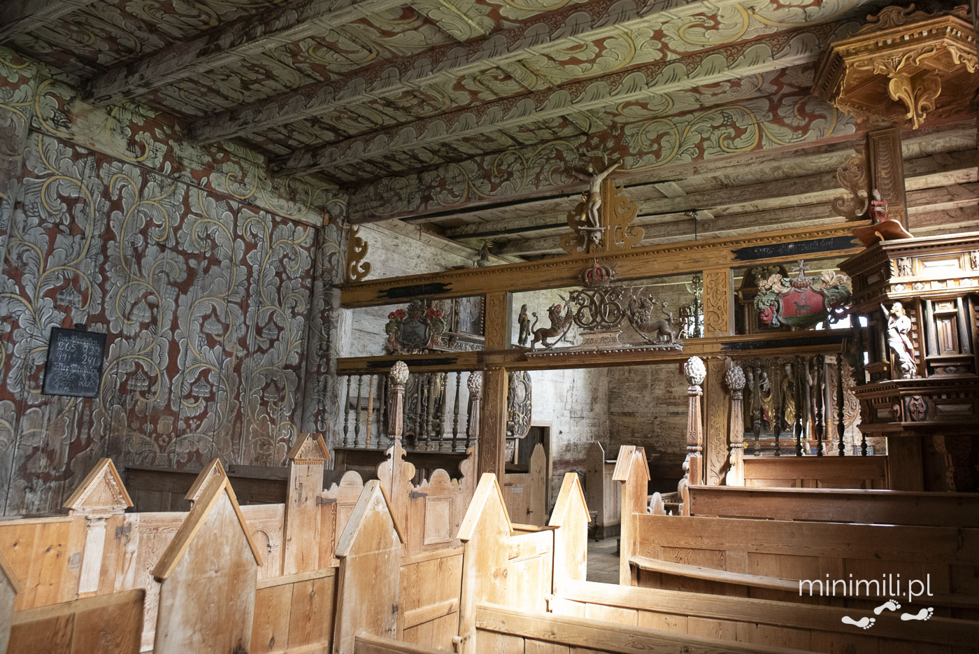 Wnętrze Kvernes Stave Church z malowanym stropem i drewnianymi ławkami