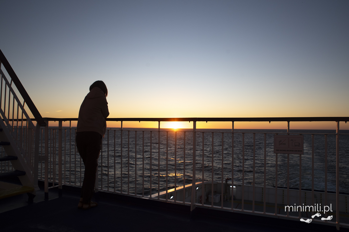 Podróżny obserwujący zachód słońca na pokładzie promu