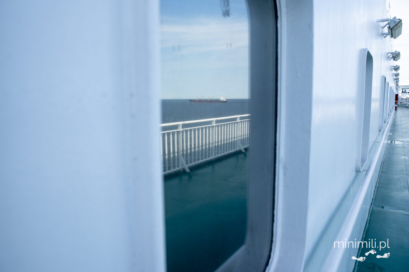 Statek na horyzoncie odbity w oknie promu
